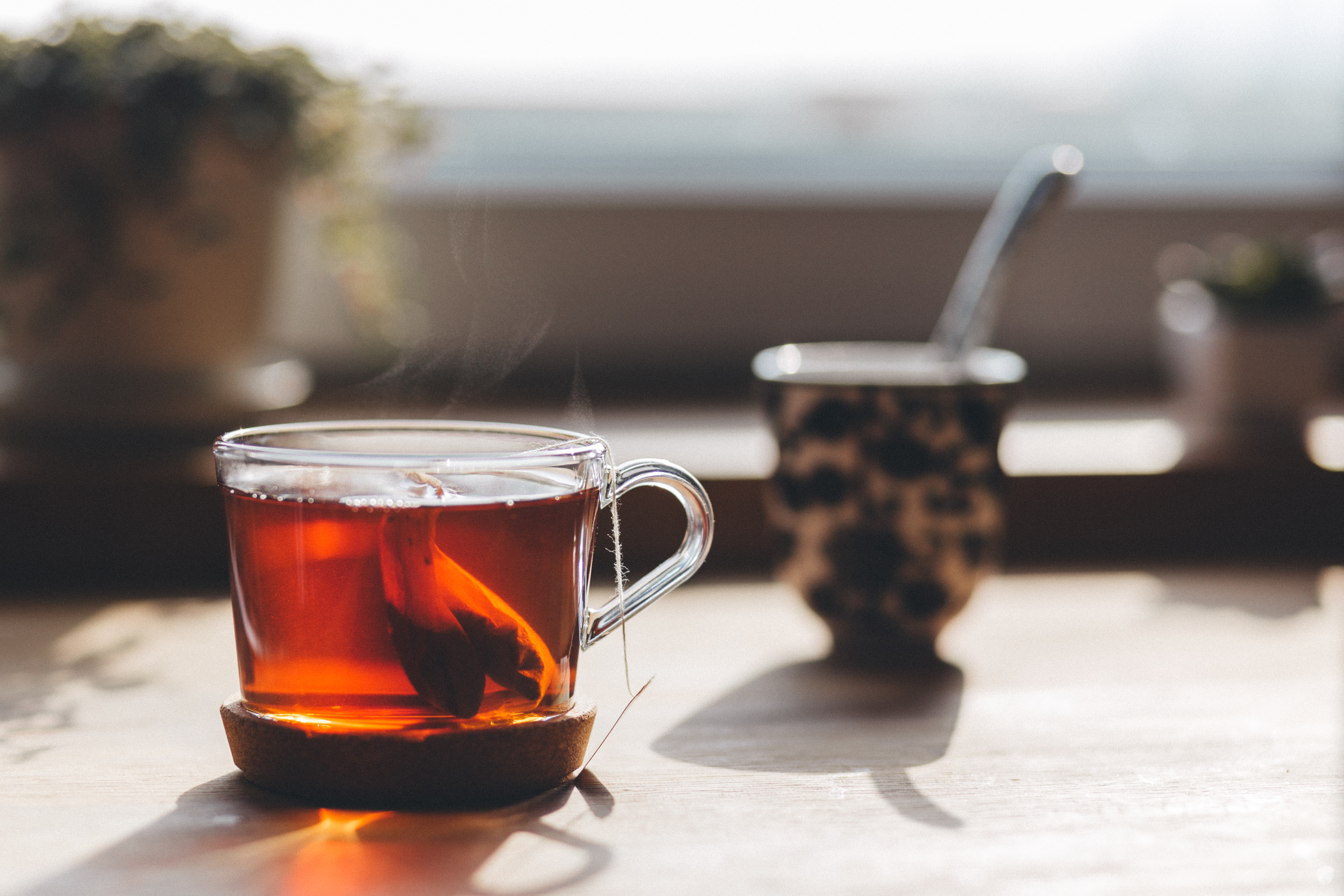 Tea steeping in a clear mug on a table.